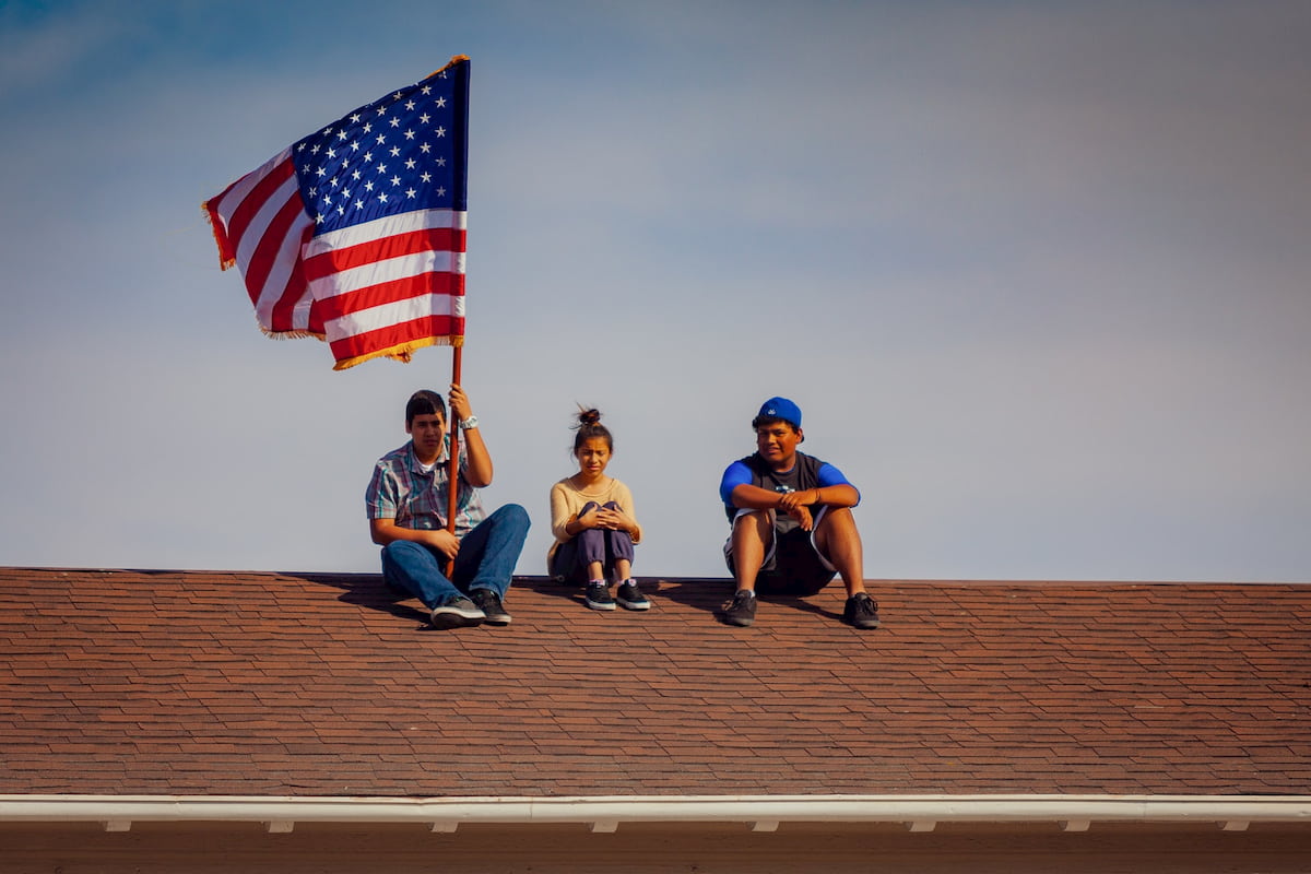 NOSOTROS WASHINGTON chicos sobre el techo con bandera
